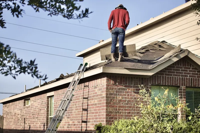 Professional roofer working on a residential roof in The Legend